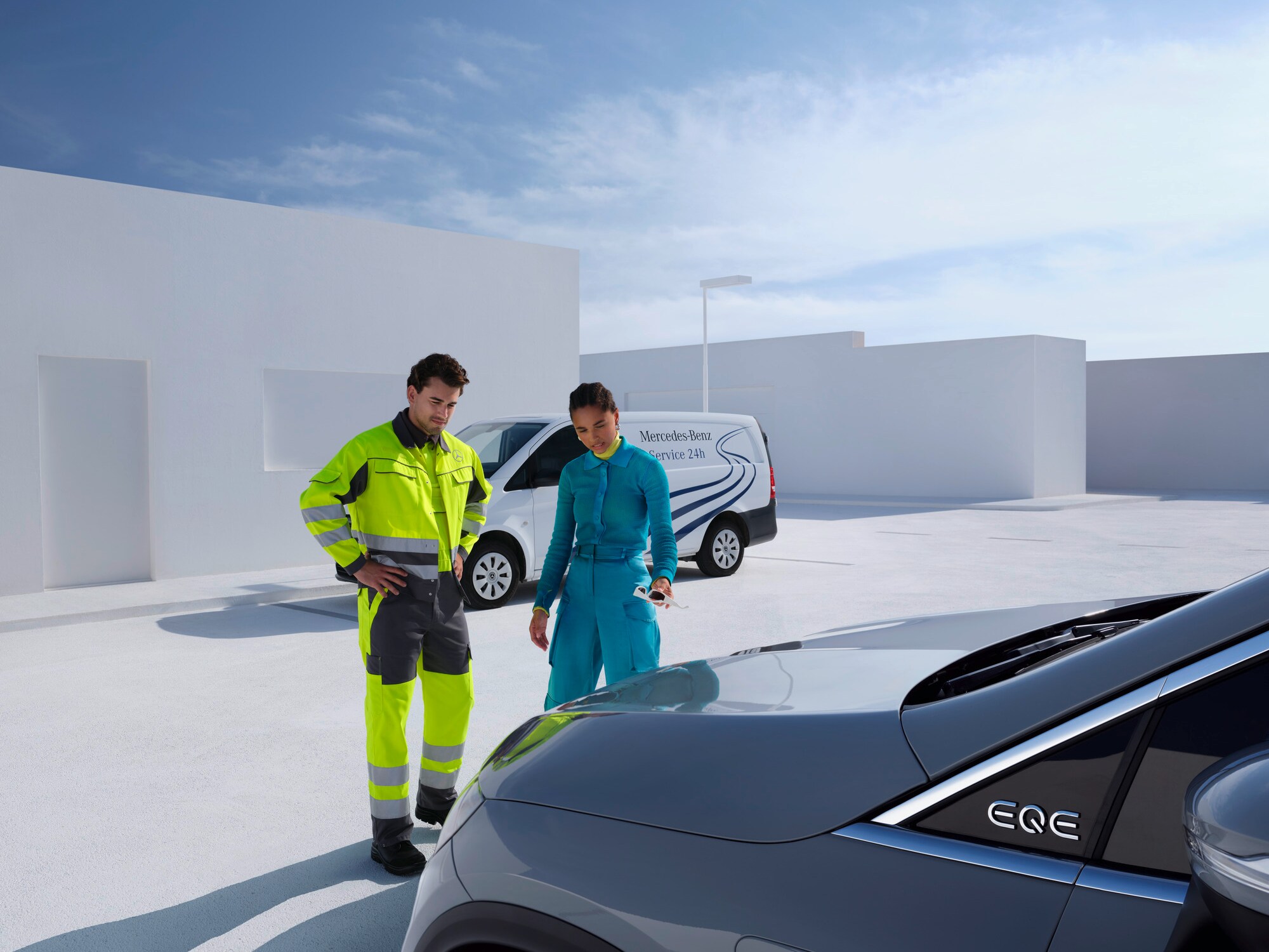 Hombre del equipo de asistencia de Mercedes-Benz Service24 junto a una mujer delante de su Mercedes-Benz