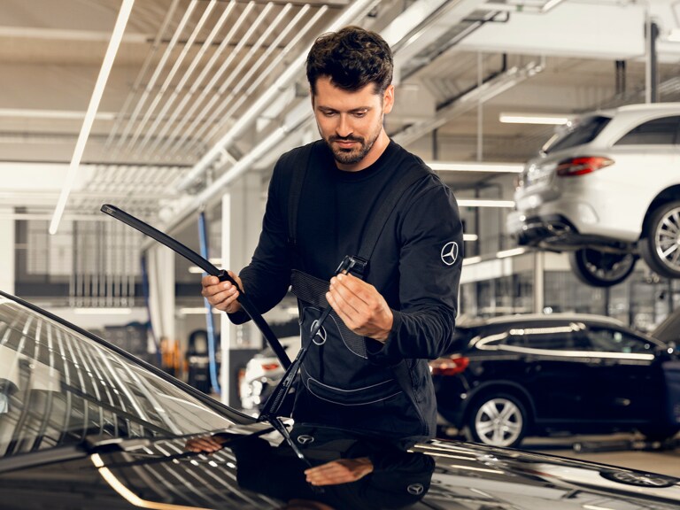 Un técnico de Mercedes-Benz cambiando el limpiaparabrisas.