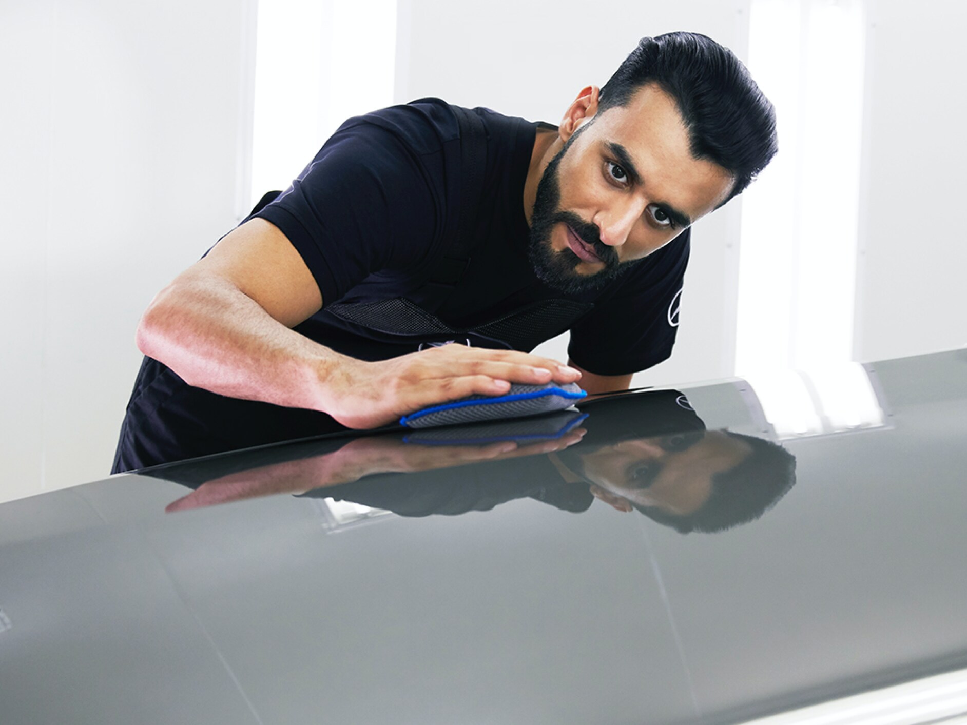 Un técnico de Mercedes-Benz examina el capó en busca de pequeños desperfectos.