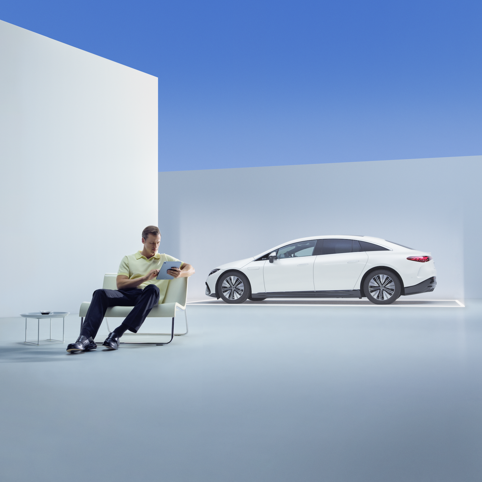 Disfrutá de todos tus recorridos sabiendo que tienes la garantía Mercedes-Benz para vehículos nuevos. | Mercedes-Benz Un hombre relajado sentado con su tableta delante de su Mercedes.